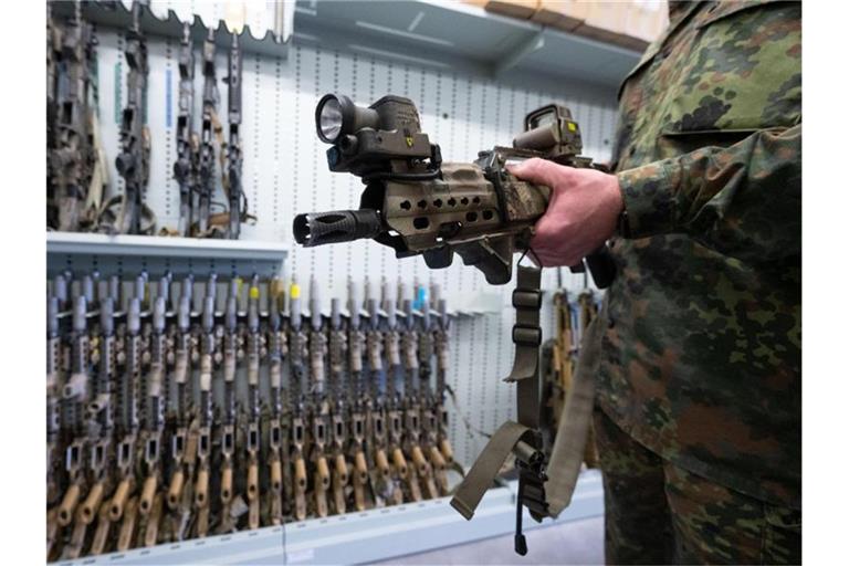 Ein spezielles Modell des G36-Sturmgewehrs von Heckler & Koch zeigt ein Soldat der Bundeswehr in einer Waffenkammer. Im Streit um einen Großauftrag gerät das Beschaffungsamt der Bundeswehr ins Visier von Kritikern. Foto: Marijan Murat/dpa