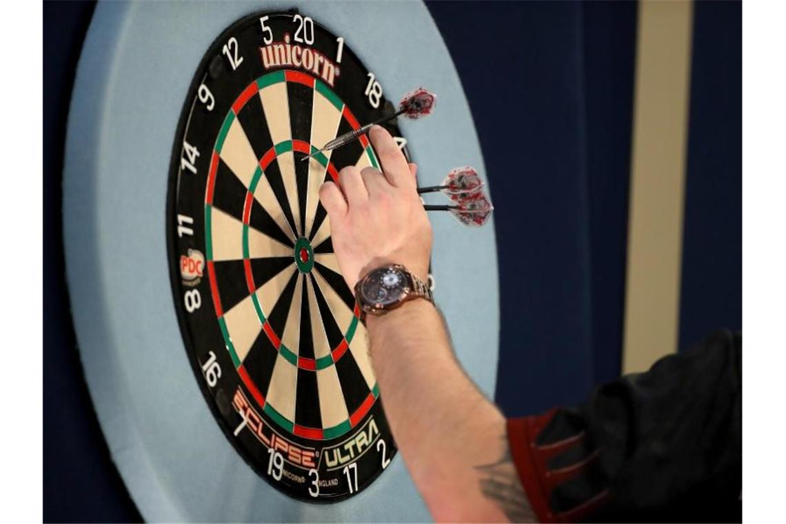 Ein Spieler holt bei der WM seine Darts vom Board.. Foto: Bradley Collyer/PA Wire/dpa