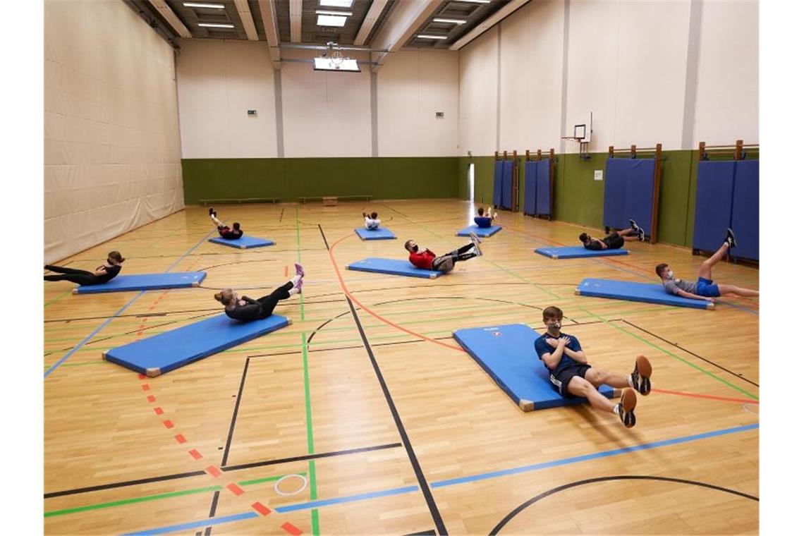 Weniger Einschränkungen im Sportunterricht Ein Sportlehrer zeigt seinen Schülern Übungen. Foto: Thomas Frey/dpa/Symbolbild