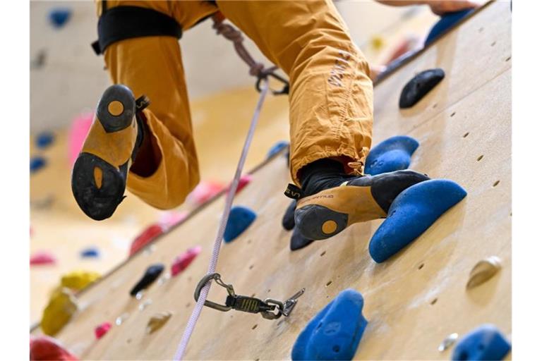 Ein Sportler klettert in einer Kletterhalle die Wand hinauf. Foto: Felix Kästle/dpa
