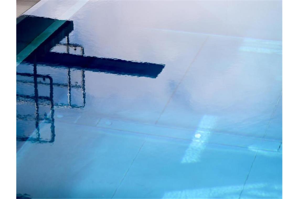 Ein Sprungturm spiegelt sich im Wasser des Sprungbeckens eines Freibads. Foto: Jan Woitas/dpa-Zentralbild/dpa/Archivbild