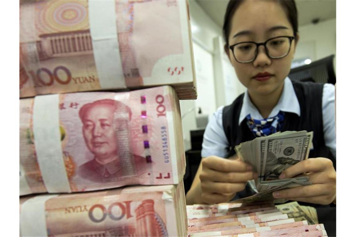 Ein Stapel Yuan-Banknoten: Chinas Notenbank stemmt sich gegen die schwächelnde Wirtschaft der Volksrepublik. Foto: Uncredited/Chinatopix/AP