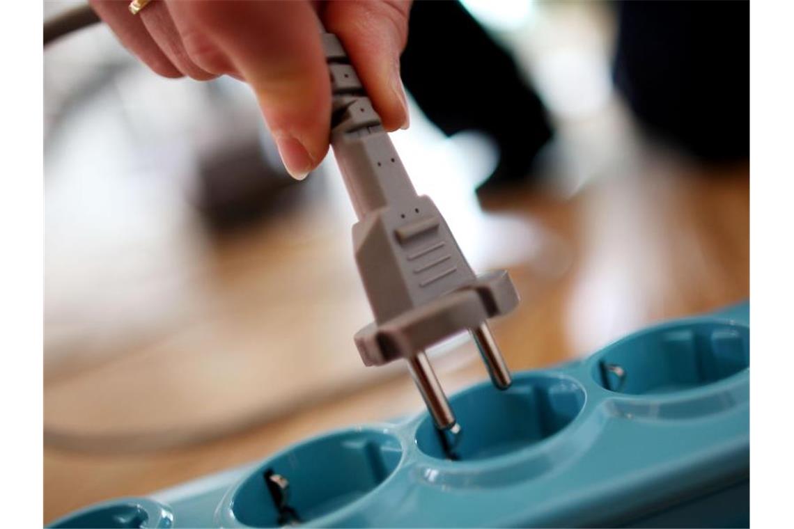 Ein Stecker wird in die Steckdose gesteckt. Foto: Oliver Berg/dpa