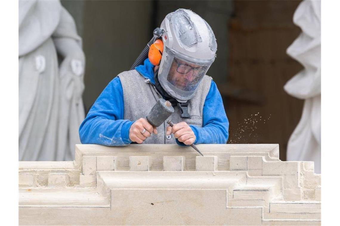 Handwerk hält Umsatz trotz Corona insgesamt stabil Ein Steinmetz arbeitet an einem Sandstein. Foto: Robert Michael/dpa/Archivbild
