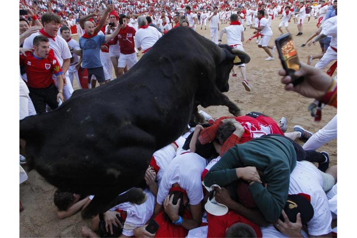 Mehrere verletzte Läufer bei vierter Stierhatz in Pamplona Ein Stier springt über auf dem Boden liegende Teilnehmer der Stierhatz. Foto: Alvaro Barrientos/AP
