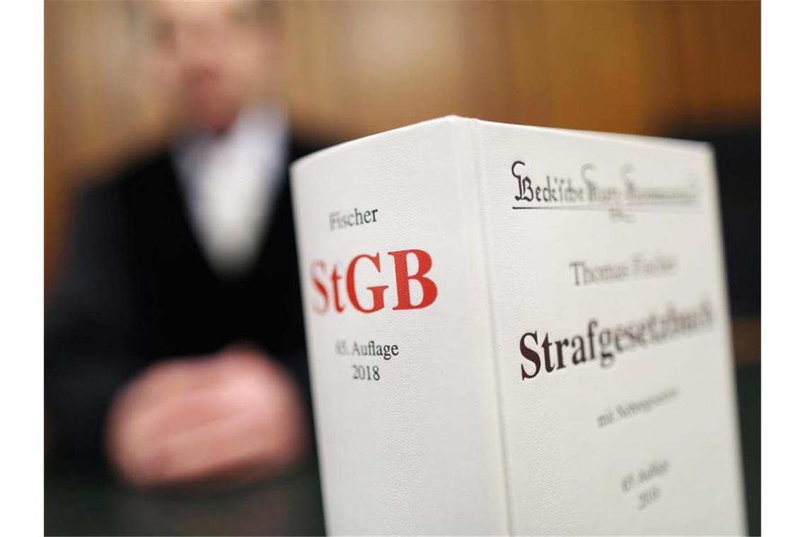Mädchen aus Rumänien missbraucht: Vorwürfe werden eingeräumt Ein Strafgesetzbuch (StGB) steht in einem Gericht auf der Richterbank. Foto: Oliver Berg/dpa/Archivbild