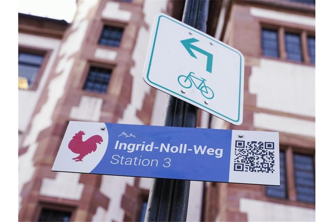Weinheim setzt Autorin Ingrid Noll ein Denkmal zu Lebzeiten Ein Straßenschild mit der Aufschrift „Ingrid-Noll-Weg Station 3“ hängt an einem Laternenpfahl. Foto: Uwe Anspach/dpa