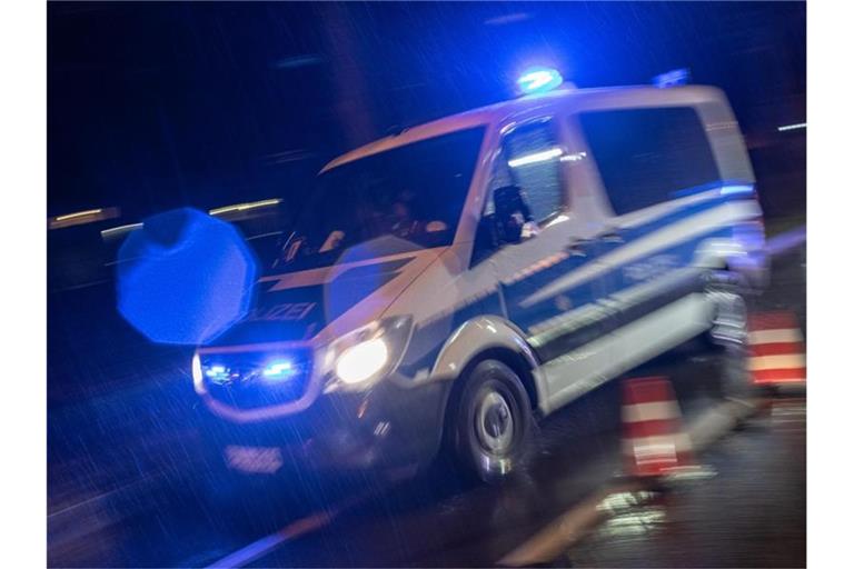 Ein Streifenwagen der Polizei fährt mit Blaulicht im Regen. Foto: Patrick Seeger/dpa/Archivbild