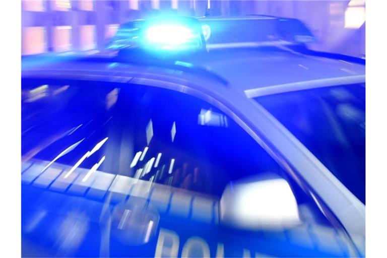 Ein Streifenwagen der Polizei steht mit eingeschaltetem Blaulicht auf der Strasse. Foto: Carsten Rehder/dpa