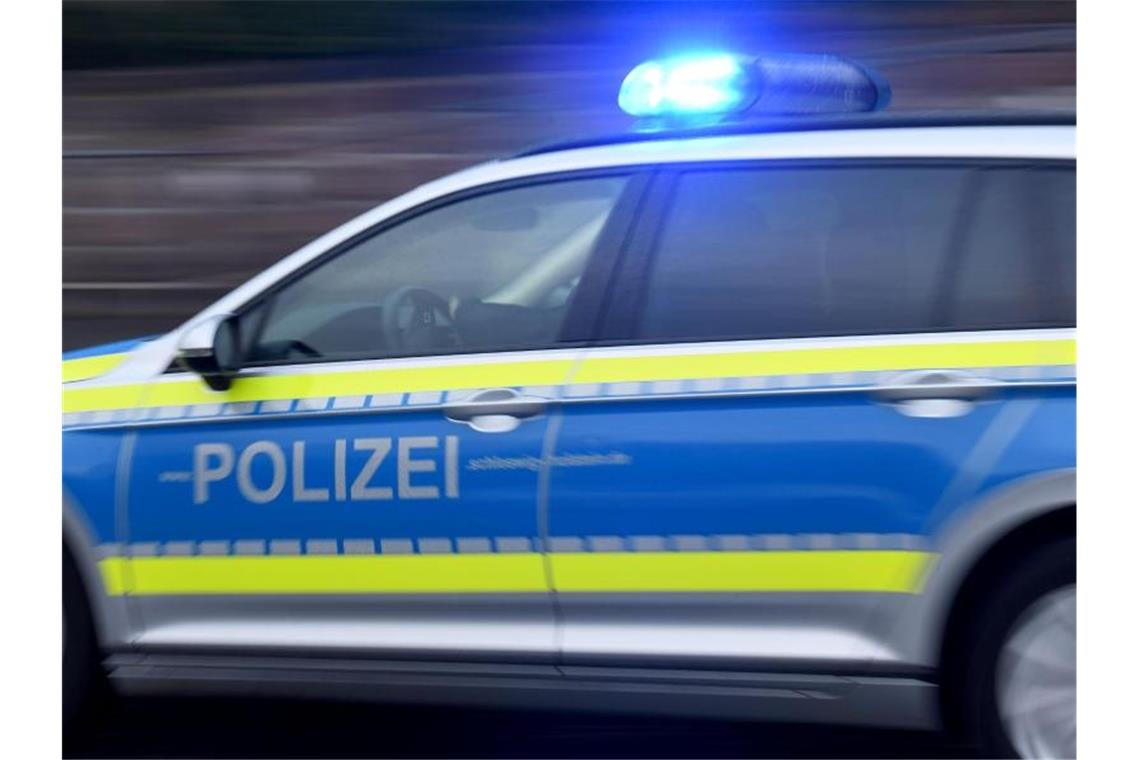 Ein Streifenwagen mit eingeschaltetem Blaulicht fährt über eine Straße. Foto: Carsten Rehder/dpa/Archivbild