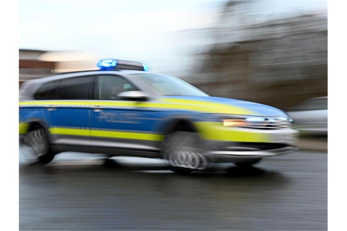 Psychisch kranker Straftäter aus Klinik geflohen Ein Streifenwagen mit eingeschaltetem Blaulicht fährt über eine Straße. Foto: Carsten Rehder/dpa/Archivbild