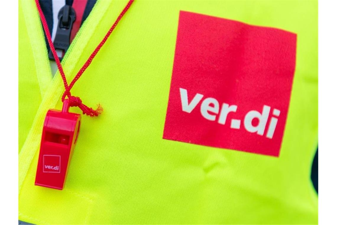 Ein Streikender trägt eine Warnweste mit dem Verdi-Logo. Foto: Christophe Gateau/dpa/Symbolbild