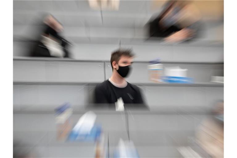 Ein Student sitzt in einer Begrüßungsveranstaltung für Studierende im ersten Semester. Foto: Sebastian Gollnow/dpa/Archivbild