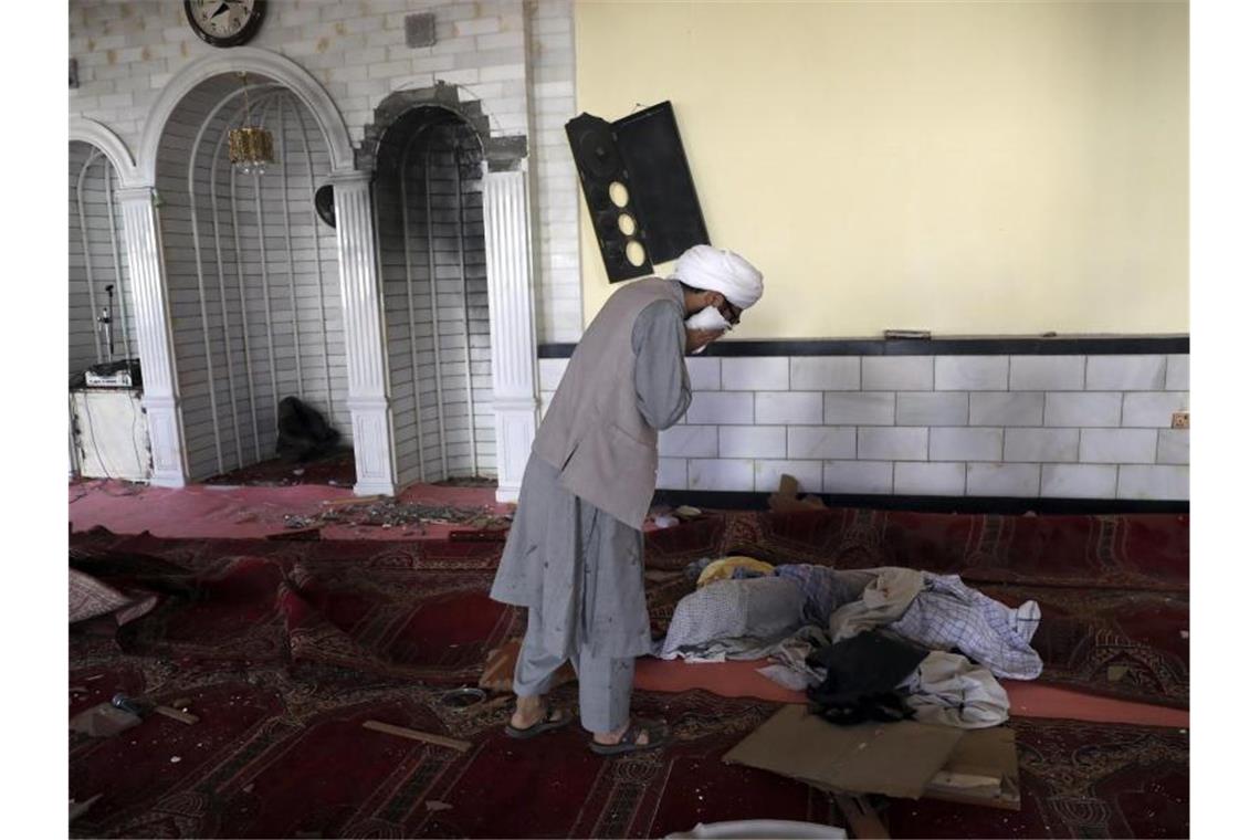 IS reklamiert Angriff auf Moschee in Afghanistan für sich Ein Student weint in der Moschee nach der Bombenexplosion. Bei einem Anschlag in Kabul sind nach Angaben der Polizei mindestens zwölf Menschen getötet worden. Foto: Rahmat Gul/AP/dpa
