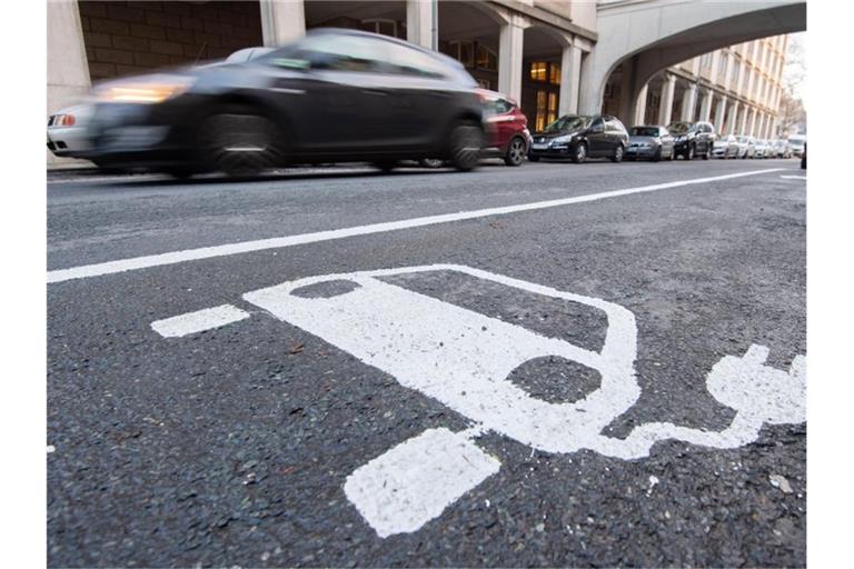 Ein Symbol eines Elektroautos markiert einen Parkplatz neben einer E-Ladesäule. Foto: Julian Stratenschulte/dpa