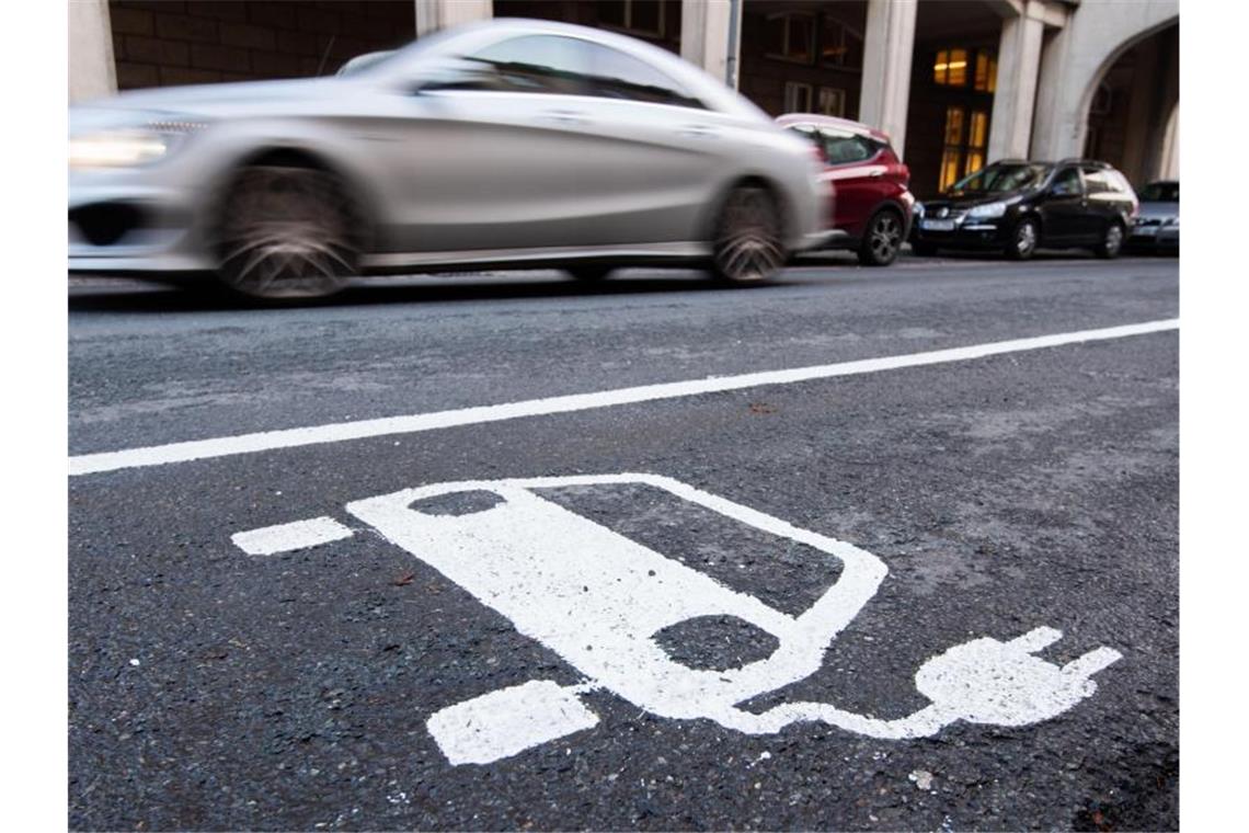 Ein Symbol eines Elektroautos markiert einen Parkplatz neben einer E-Ladesäule. Foto: Julian Stratenschulte/dpa