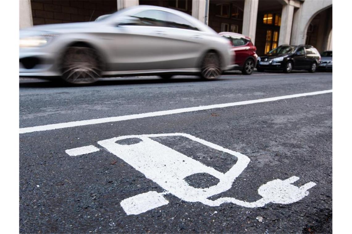 Studie zu mobilen Parkplatz-Robotern für E-Autos Ein Symbol eines Elektroautos markiert einen Parkplatz neben einer E-Ladesäule. Foto: Julian Stratenschulte/dpa