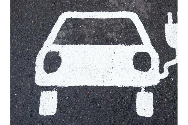 Ein Symbol für ein E-Auto markiert einen Parkplatz neben einer E-Ladesäule. Foto: Julian Stratenschulte/dpa/Symbolbild