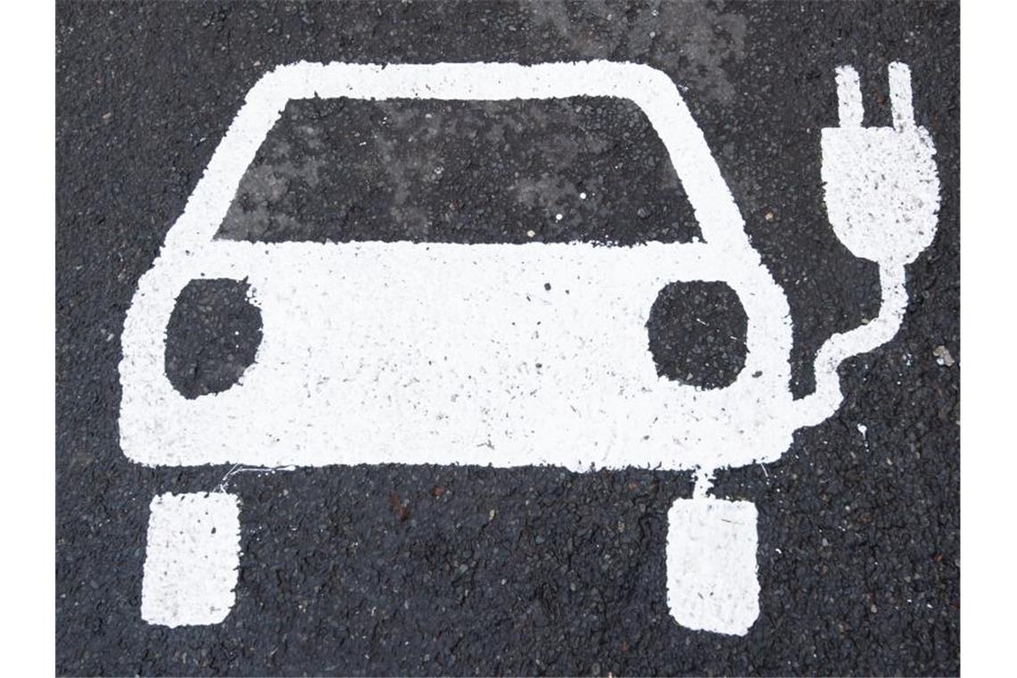 Ein Symbol für ein Elektroauto markiert einen Parkplatz neben einer E-Ladesäule. Foto: Julian Stratenschulte/dpa