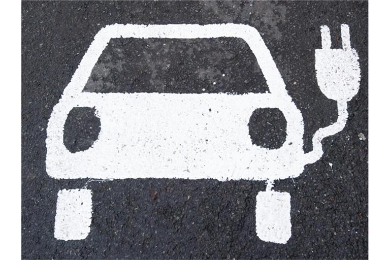 Ein Symbol für ein Elektroauto markiert einen Parkplatz neben einer E-Ladesäule. Foto: Julian Stratenschulte/dpa