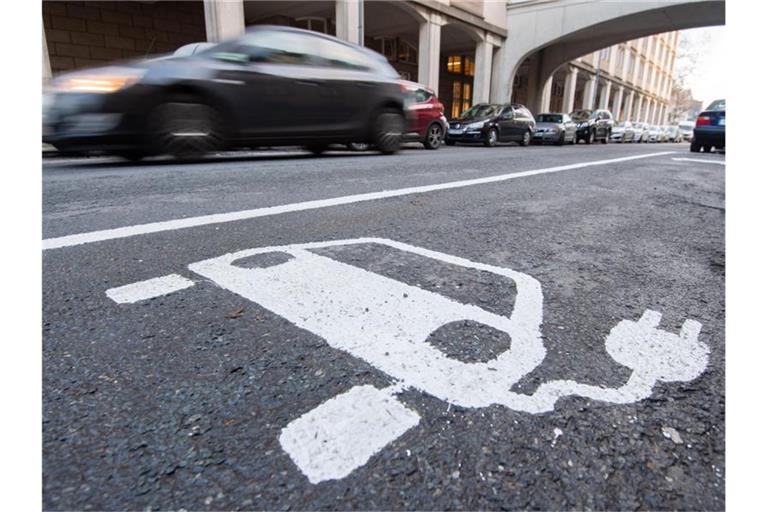 Ein Symbol für ein Elektroauto markiert einen Parkplatz neben einer E-Ladesäule. Foto: Julian Stratenschulte/dpa