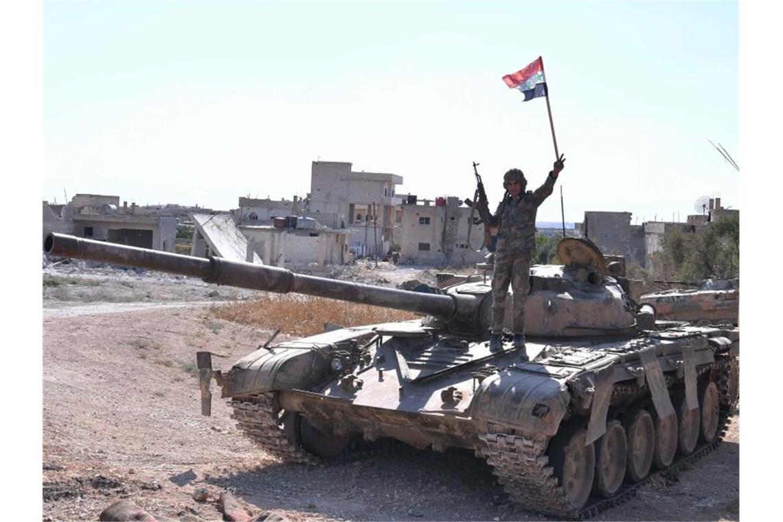 Ein syrischer Soldat zeigt auf einem Panzer das Victory-Zeichen. Foto: Ammar Safarjalani/XinHua