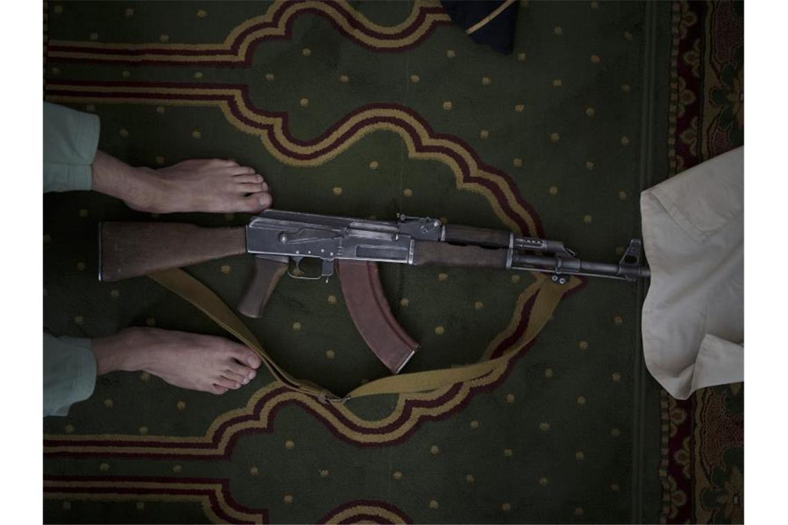 Ein Taliban-Kämpfer nimmt seine Kalaschnikow von Typ AK-47 zum Beten mit in eine Moschee. Foto: Felipe Dana/AP/dpa