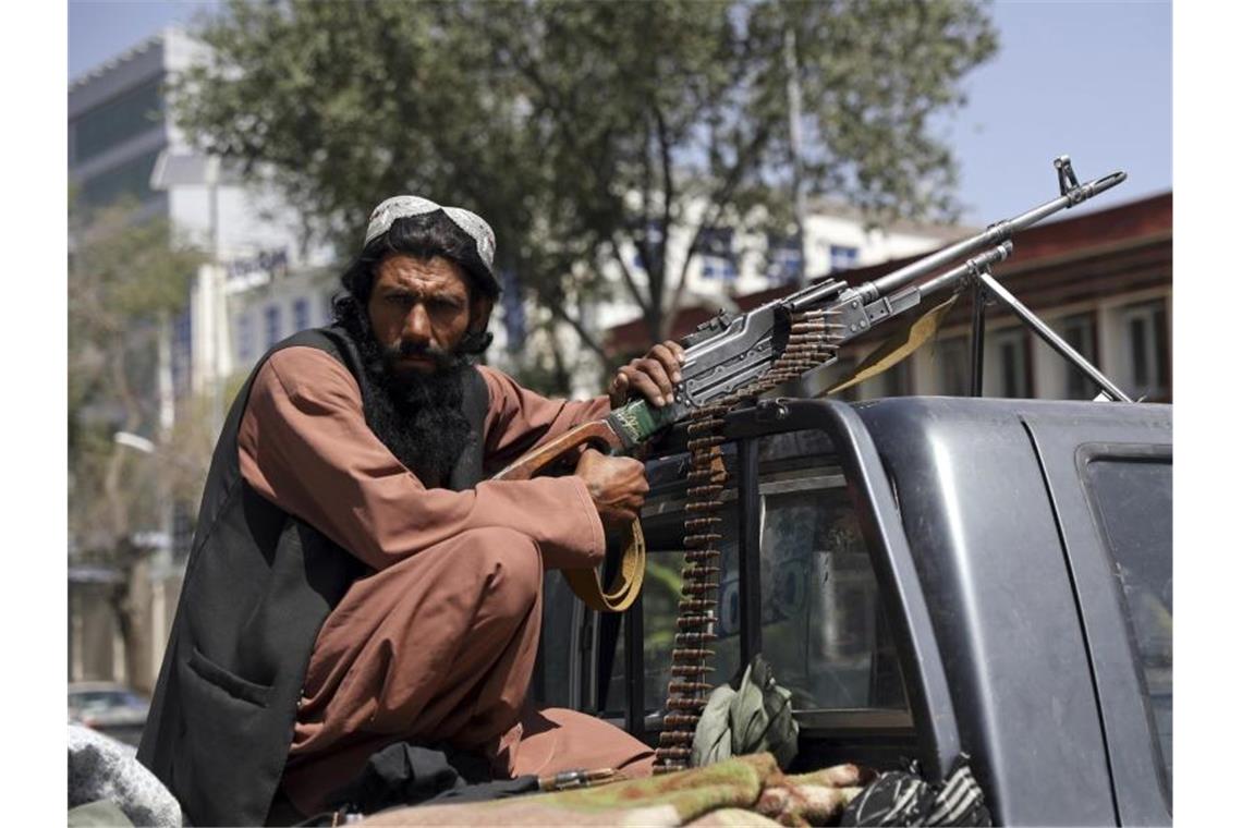 Ein Taliban-Kämpfer vor dem Haupttor zum Präsidentenpalast in Kabul. Foto: -/AP/dpa
