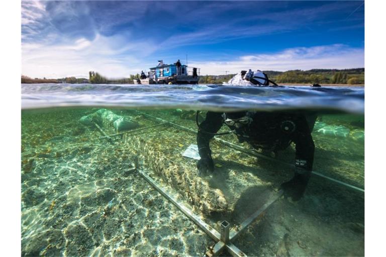Ein Taucher arbeitet an einem Fund eines rund 4000 Jahre alten Einbaums im Bodensee. Foto: Florian Huber/Wirtschaftsministerium/dpa