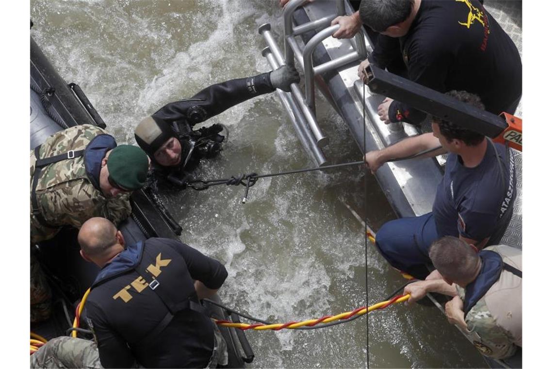 Nach Schiffsunglück: Leiche 100 km von Budapest geborgen Ein Taucher spricht mit Rettungskräften. Rund 100 Kilometer südlich von Budapest konnte ein weiteres Opfer der Schiffskatastrophe geborgen werden. Foto: Laszlo Balogh/AP