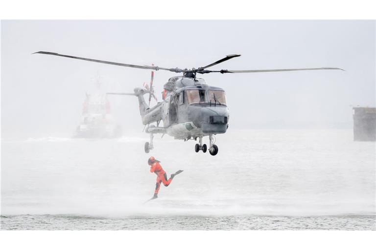 Ein Taucher springt im Rahmen einer Vorführung auf dem Marinestützpunkt Wilhelmshaven aus einem Hubschrauber.
