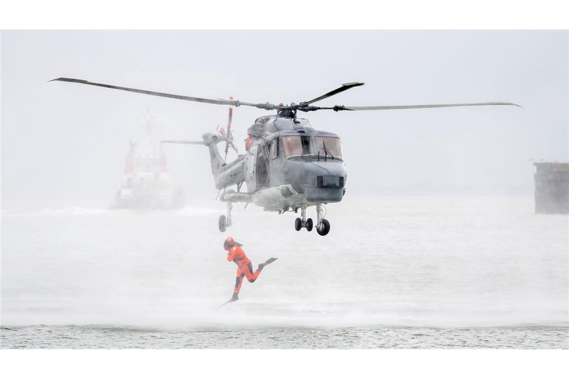 Bilder des Tages Ein Taucher springt im Rahmen einer Vorführung auf dem Marinestützpunkt Wilhelmshaven aus einem Hubschrauber.