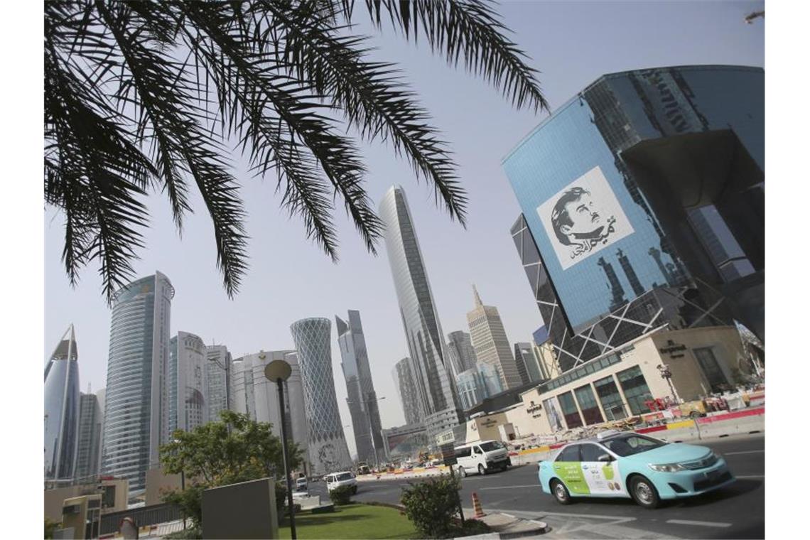 Ein Taxi fährt in Doha an einem Gebäude mit einem Bild des Emirs von Katar, Tamim bin Hamad Al Thani, vorbei. Der Streit zwischen Katar und seinen Nachbarn ist beigelegt. Foto: Kamran Jebreili/AP/dpa