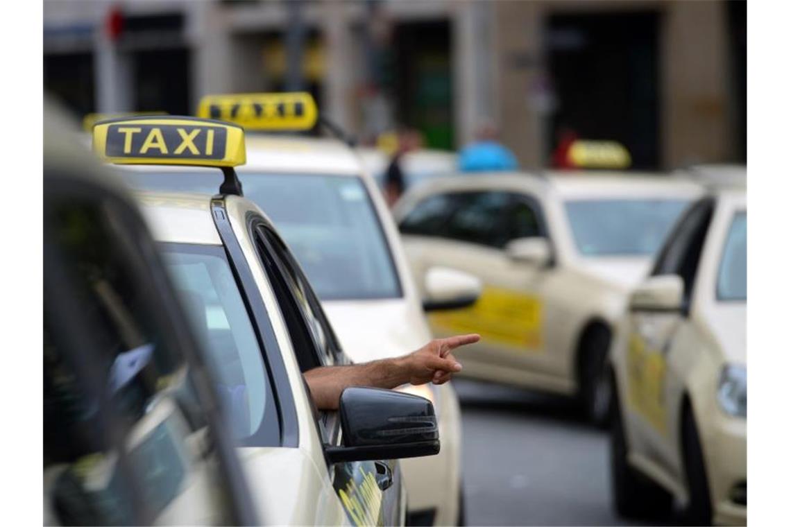 Skepsis gegenüber Schnellladestation für E-Taxis Ein Taxifahrer steht in der Warteschlange auf dem Taxistand und gestikuliert mit seiner Hand. Foto: Andreas Arnold/Archiv