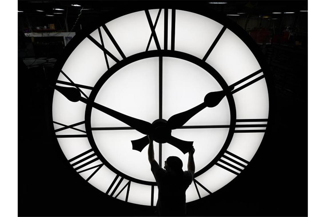 Sommerzeit hat begonnen Ein Techniker bewegt die Uhrzeiger einer 500 kg schweren Uhr. Foto: Elise Amendola/AP/dpa