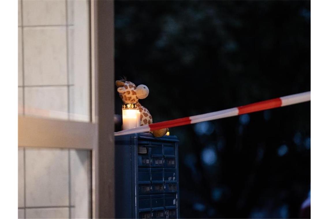 Ein Teddybär und eine Kerze vor dem Wohnhaus in Solingen. Foto: Marcel Kusch/dpa