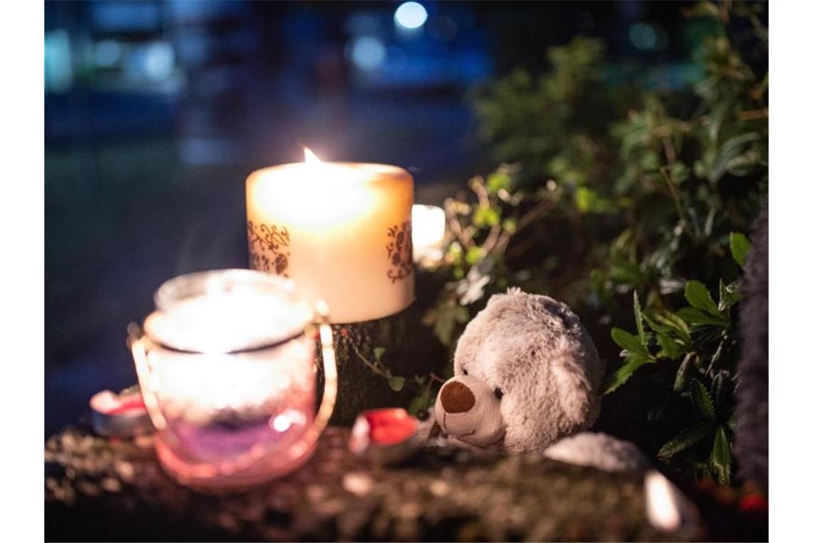 Ein Teddybär und Kerzen liegen und stehen vor einem Haus. Eine 27-jährige Mutter soll in Solingen fünf Kinder umgebracht haben. Foto: Marcel Kusch/dpa