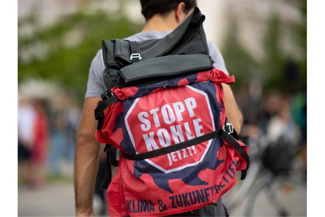 Ein Teilnehmer einer „Fridays for Future“-Klimademonstration hat an seinem Rucksack ein Transparent mit der Aufschrift „Stopp Kohle jetzt!“ befestigt. Foto: Monika Skolimowska