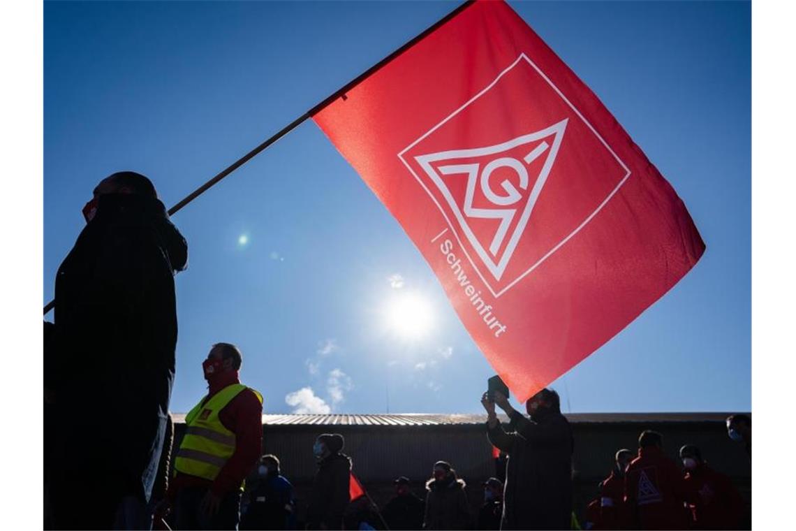 Metall-Tarifverhandlungen im Südwesten weiter ohne Ergebnis Ein Teilnehmer eines Warnstreiks schwenkt eine Fahne mit dem Logo der IG Metall. Foto: Nicolas Armer/dpa/Symbolbild