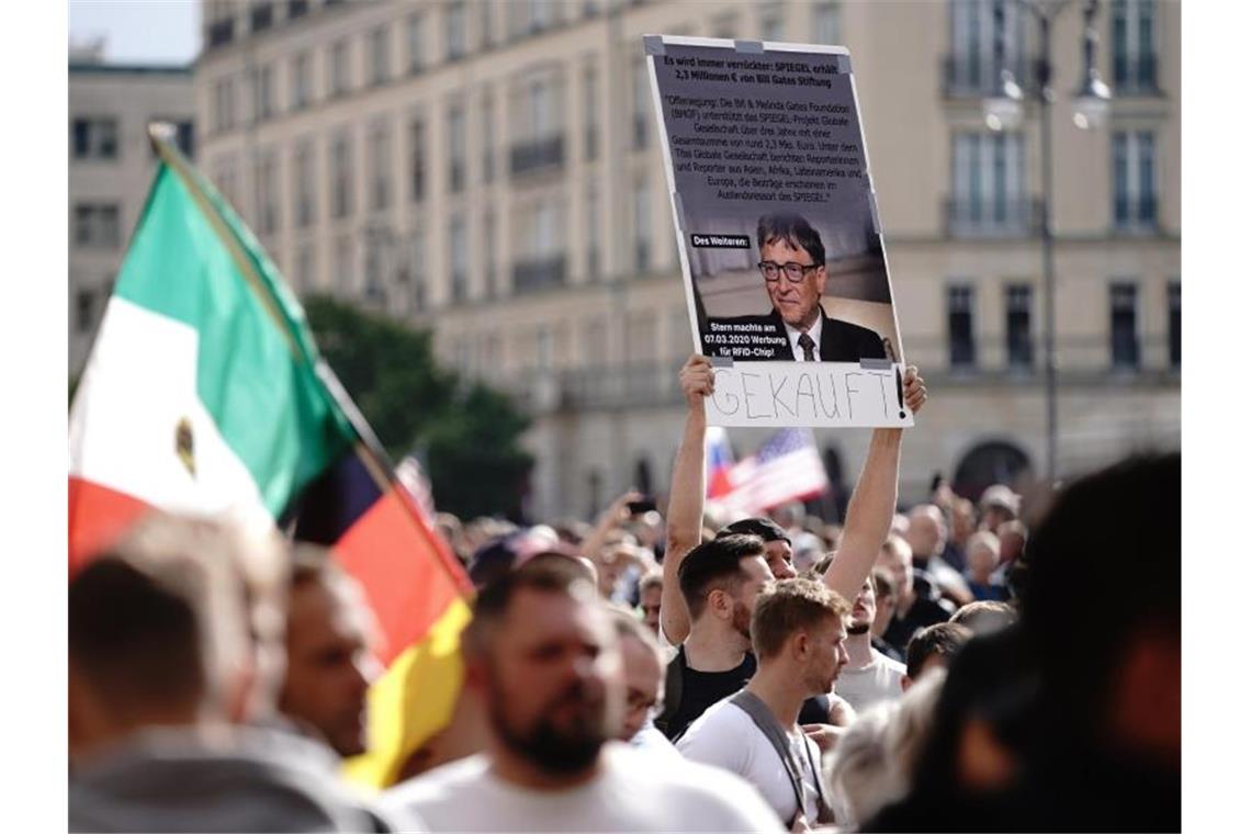 Ein Teilnehmer hält ein Plakat von Bill Gates und dem Schriftzug Gekauft! vor einer Demonstration gegen die Corona-Maßnahmen. Foto: Kay Nietfeld/dpa