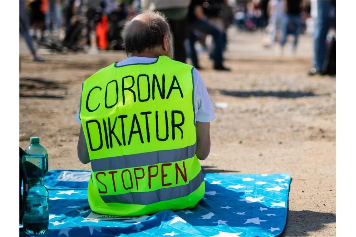 Ein Teilnehmer trägt auf dem Cannstatter Wasen bei einer Kundgebung der Initiative „Querdenken 711“ eine Warnweste mit der Aufschrift „Corona Diktatur stoppen“. Foto: Christoph Schmidt/dpa