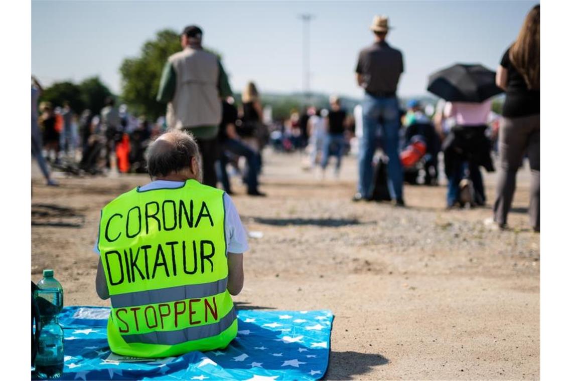 Ein Teilnehmer trägt auf dem Cannstatter Wasen in Stuttgart eine Warnweste mit der Aufschrift „Corona Diktatur stoppen“. Foto: Christoph Schmidt/dpa