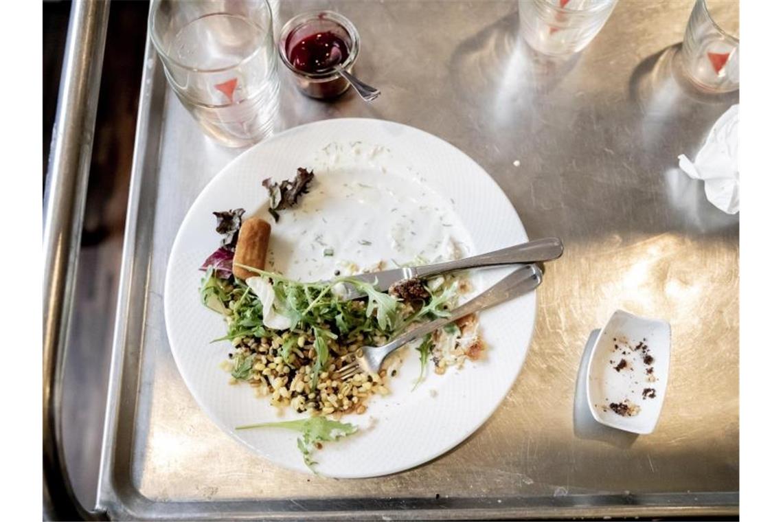 Etwa 13 Millionen Tonnen Essen werden pro Jahr verschwendet Ein Teller mit Essensresten ist im H4 Hotel am Alexanderplatz auf einem Küchenwagen zu sehen. Foto: Christoph Soeder/Archivbild