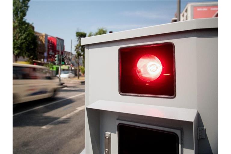 Ein Tempomessgerät blitzt ein vorbeifahrendes Auto. Foto: Daniel Reinhardt/dpa/Symbolbild