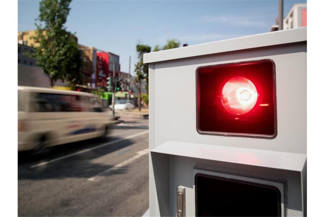 Ein Tempomessgerät blitzt ein vorbeifahrendes Auto. Foto: Daniel Reinhardt/dpa/Symbolbild