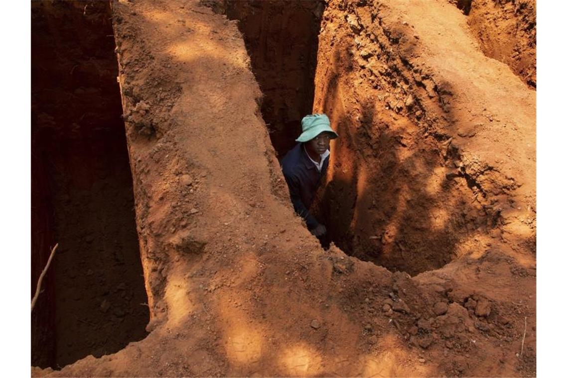 Mehr als eine Million Corona-Tote weltweit Ein Totengräber auf dem Westpark-Hauptfriedhof in Johannesburg. Seit Beginn der Corona-Pandemie sind weltweit bereits mehr als eine Million Menschen nach einer Infektion mit dem neuartigen Coronavirus gestorben. Foto: Denis Farrell/AP/dpa