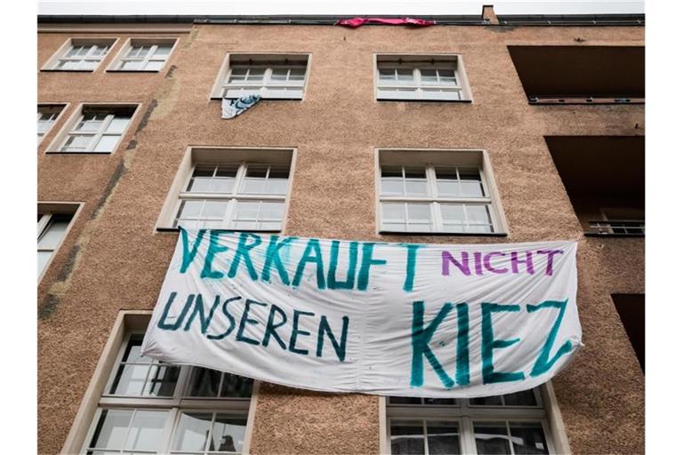 Ein Transparent gegen Investoren und Gentrifizierung hängt an der Fassade eines Hauses in Berlin-Neukölln. Foto: Christoph Soeder/dpa