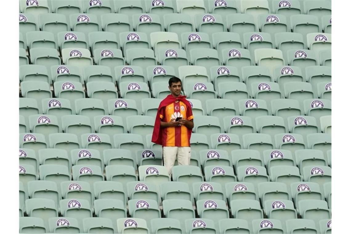 Ein türkischer Fan steht weit vor Spielbeginn auf der Tribüne. Foto: Darko Vojinovic/AP Pool/dpa