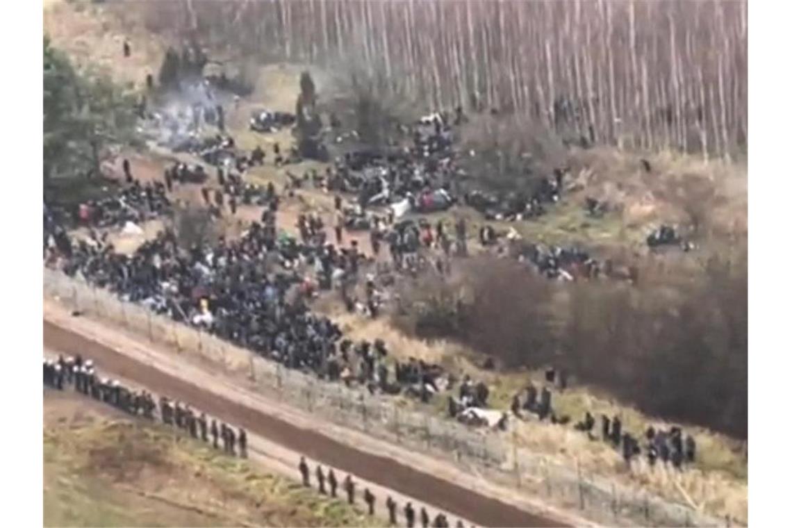 Ein TV-Bild zeigt Migranten auf dem Weg zur belarussisch-polnischen Grenze. Foto: Polish Ministry Of National Defe/PAP/dpa