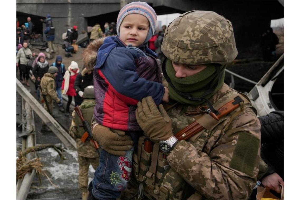 Russland setzt Angriff auf Mariupol fort Ein ukrainischer Soldat bringt ein Baby über den Fluss Irpin. Foto: Vadim Ghirda/AP/dpa